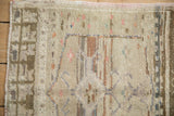 Vintage Oushak rug corner showing the even wear, low pile, and secured side cord.