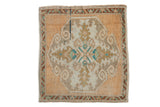 Distressed vintage Oushak square rug: tangerine orange field, ivory medallion, scrolled ram's horn.