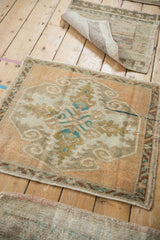 Distressed vintage Oushak rug corner with faded tangerine field, serrated buds, and scrolled outlines.