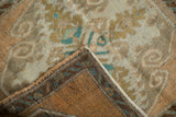 Distressed vintage Oushak rug corner revealing worn pile and detailed hand-knotted foundation.
