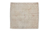 Faded ivory and cream distressed Oushak square rug with subtle medallion pattern.