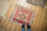 Distressed vintage Oushak square rug with blush pink, green palmettes, and charming even wear.