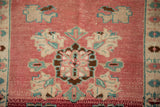 Distressed Oushak rug with blush pink abrashed field and faded floral palmette motifs.