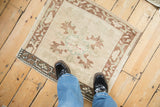 The distressed texture and real-world scale of a small vintage Oushak rug mat.