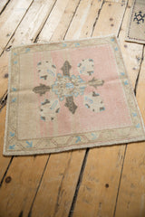Patinaed quatrefoil medallion in dusty rose, sky blue, and charcoal on a vintage Oushak.