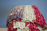 Textural detail of folk art American Flag rag rug with sewn stars and frayed fabric.