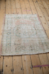 Intact pink side selvage of the vintage Oushak rug, revealing distressed rose and green pile.