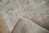 Vintage Distressed Oushak rug showing worn pile texture, white fringe, and pink selvage.