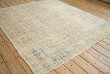 Distressed texture and visible foundation on the beige Oushak square carpet.