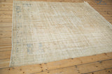 Corner detail of distressed vintage Oushak rug showing muted beige pile and foundation wear.