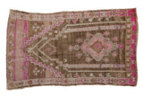 Distressed vintage Oushak prayer rug, pink floral medallion on an abrashed brown field.