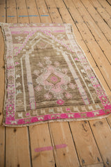 Distressed Oushak rug's muted coffee ground with prayer motif and vibrant pinks.