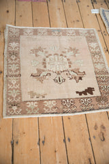 Distressed Oushak rug corner, showing faded ivory pile and traditional germinating plant border.