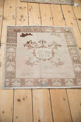 Distressed Oushak rug's corner detail highlighting germinating plant border and soft colors.