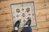 A person's perspective looking down at a small distressed Oushak rug mat for scale.