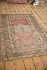 Distressed Anatolian rug showing worn blush pile, stepped pattern, and faded bronze borders.