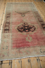 Distressed Oushak rug pile detail with serrated aubergine medallion and abrashed rose ground.
