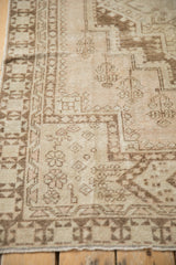 Faded ivory and chocolate brown geometric patterns with worn pile on vintage Oushak rug.