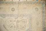 Distressed vintage Sparta carpet corner, with low pile, visible foundation, and soft blue motifs.