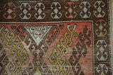 Distressed Oushak runner detail: chocolate brown border, terracotta field, sky blue hook and latch motifs.