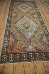 Distressed Oushak runner detail: chocolate brown border with geometric hook and latch motifs.