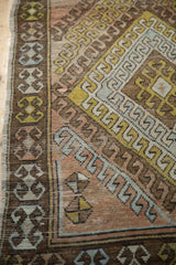 Distressed Oushak runner's brown border with blue hook motifs and worn terracotta pile.