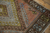 Distressed Oushak runner edge detail with chocolate brown, blue, and greenish-gold motifs.