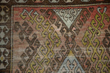 Distressed Oushak runner, textured pile, geometric hook and latch motifs in terracotta, gold, brown.