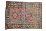 Distressed vintage Oushak rug: prayer motif, double stepped medallion, blue, red, ivory tones.