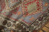 Distressed Oushak rug mat's softened pile, muted floral border, and geometric starburst patterns.
