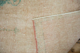 Worn distressed pile of a vintage Oushak rug, showing foundation and blush selvage.