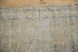 Distressed Oushak runner pile with worn royal blue vines on an ivory ground.