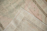 Distressed vintage Oushak rug pile in dusty rose and silver, revealing hand-knotted foundation.