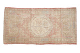 Vintage distressed Oushak rug runner with a roundel medallion in soft blush, beige, and faded blue.