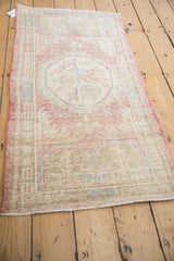 Angled view of a distressed Oushak runner with a soft blush and beige palette.