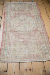 Low angle view of the distressed Oushak runner, highlighting its worn texture and faded pattern.