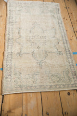 Vintage Oushak runner in ivory and cream, displaying distressed texture and wear.