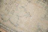 Distressed vintage Oushak rug texture, highlighting low pile and visible foundation in ivory and blue.