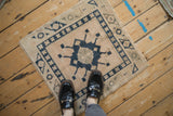 Vintage Oushak rug's distressed geometric navy blue and cream pattern underfoot.