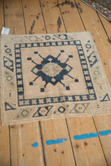 Distressed Oushak rug corner with dusty navy geometric borders, cream starburst. Short pile.