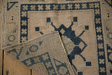 Secured edge and hand-knotted backing of vintage Oushak rug with dusty navy geometric pattern.