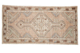 Distressed Oushak runner with hexagonal medallion, dusty mauve, slate blue, and brown tones.