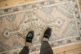 Soft mauve, blue, and beige distressed Oushak runner with worn pile underfoot.