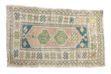 Vintage distressed Oushak rug with a double medallion and geometric borders in sandalwood, blue, and green hues.