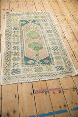 A distressed Turkish Oushak rug displaying mostly even wear across its geometric medallion pattern.