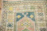 Detailed view of the meandering zig-zag border and low-pile texture of a vintage Turkish Oushak rug.
