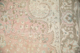 Detail of distressed vintage Persian Tabriz rug: dusty rose field, sand florals, and soft pile.