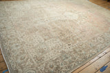 Distressed Tabriz carpet corner with intricate vine motifs, dusty beige, and soft rose tones.