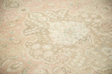 Distressed vintage Tabriz carpet texture, with sprawling vines in dusty rose and sand.