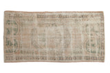 Distressed vintage Oushak runner rug featuring cream, dusty rose, green medallion, 2' x 3'10